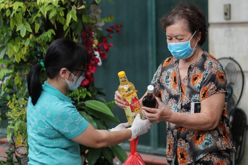 Người dân khu Trúc Bạch nhận tiếp tế thực phẩm từ người thân chuyển đến. (Ảnh: Thành Đạt/TTXVN)
