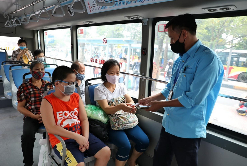 Hành khách và nhân viên xe buýt đều đeo khẩu trang. (Ảnh: Danh Lam/TTXVN)