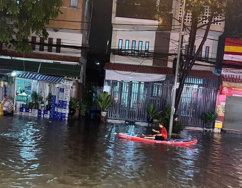 Người dân phải dùng thuyền để di chuyển tại khu vực ngã ba cống trên đường Thích Quảng Đức, thành phố Thủ Dầu Một, tỉnh Bình Dương. (Ảnh: TTXVN phát)