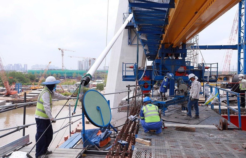 Công nhân thi công căng cáp trên phần cầu chính dự án cầu Thủ Thiêm 2. (Ảnh: TTXVN phát)