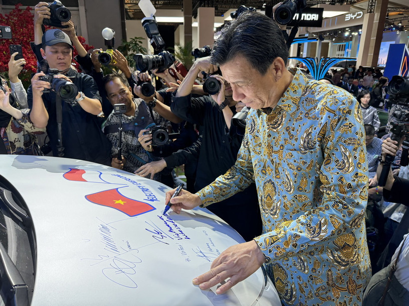 Đại sứ Việt Nam tại Indonesia Tạ Văn Thông ký tên vào chiếc xe trưng bày của Vinfast. (Ảnh: Đỗ Quyên/Vietnam+)