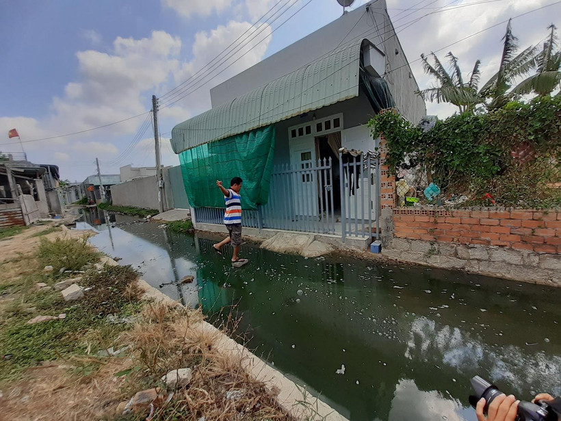 Để vào được nhà, người dân ấp Phước Lâm phải kê các hòn đá, xe máy phải gửi nhà hàng xóm. Ảnh: Hoàng Nhị - TTXVN
