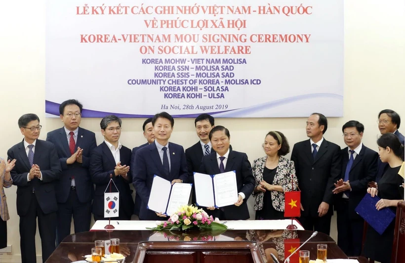 Thứ trưởng Bộ Lao động-Thương binh và Xã hội Lê Tấn Dũng và Thứ trưởng Bộ Y tế và Phúc lợi xã hội Hàn Quốc Ganglip Kim ký kết Bản ghi nhớ hợp tác trong lĩnh vực phúc lợi xã hội. (Ảnh: Anh Tuấn/TTXVN)