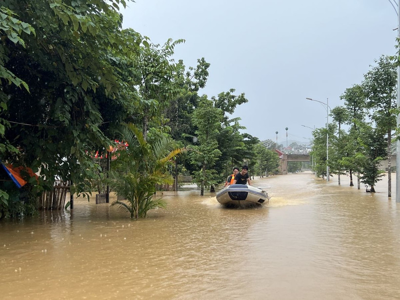 Lực lượng chức năng dùng xuồng cứu hộ giúp đỡ người dân trong vùng ngập lụt. (Ảnh: Chu Hiệu/TTXVN)