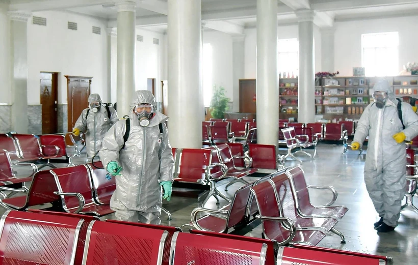 Phun thuốc khử trùng tại một địa điểm ở Triều Tiên ngày 15/2. (Ảnh: AFP/TTXVN)