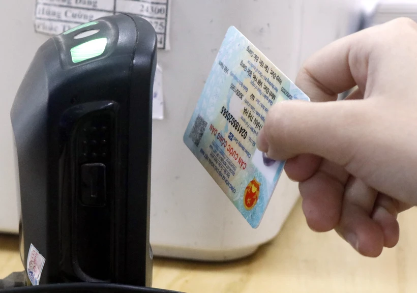 Dùng máy quét QR code trên Căn cước công dân gắn chíp để tra cứu thông tin người bệnh. (Ảnh: Đồng Thúy-TTXVN/)