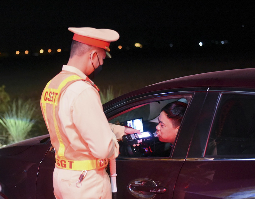 Cảnh sát Giao kiểm tra nồng độ cồn của người tham gia giao thông. (Ảnh: Xuân Tư/TTXVN)