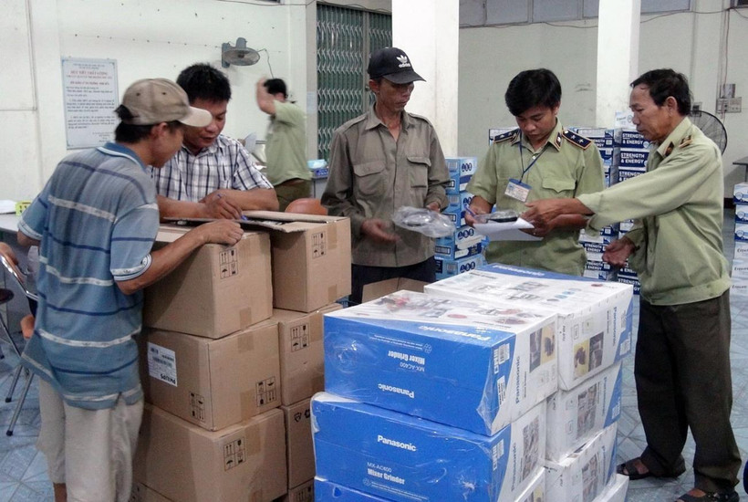 Lực lượng chức năng kiểm tra lô hàng hóa vừa bị bắt giữ. (Ảnh: Thế Lập/TTXVN)