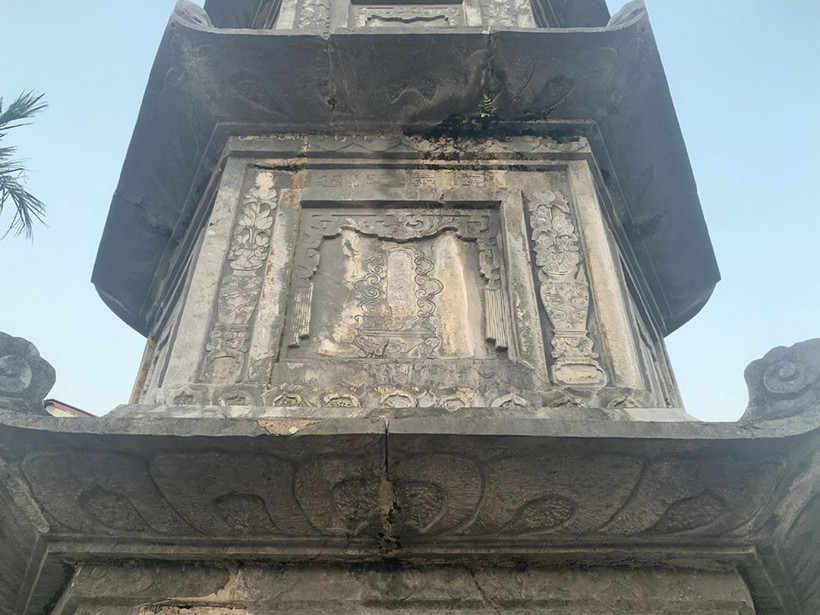 Di tích cửu phẩm liên hoa hiện bị rêu mốc bám bề mặt, xuất hiện khe hở ở chân đế và góc, cạnh của các tầng tháp, sứt vỡ mất mảnh nhỏ tại các diềm mái. (Ảnh: TTXVN phát)