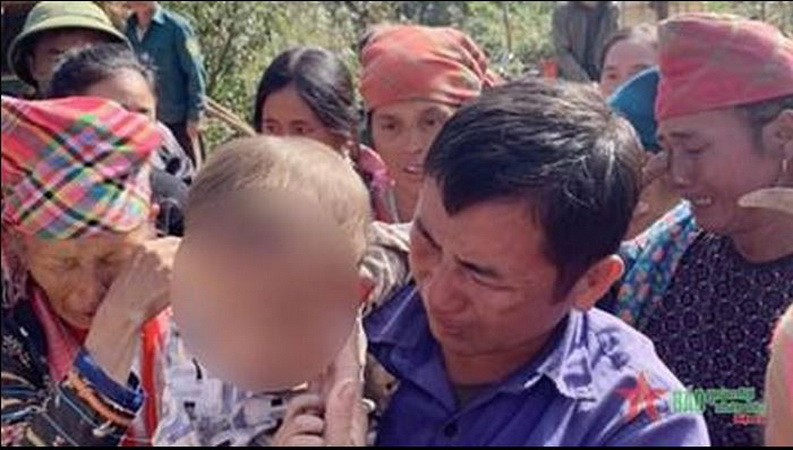 Gia đình anh Trình A Vàng tiếp nhận cháu bé từ lực lượng tìm kiếm. (Nguồn: báo Quân đội Nhân dân)