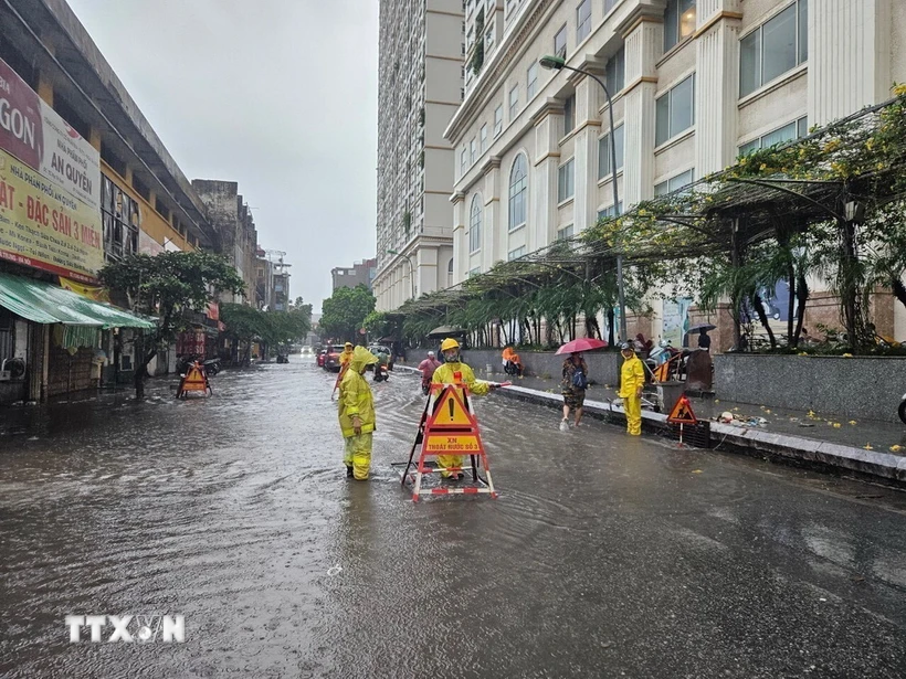 Công nhân Công ty Thoát nước Hà Nội ứng trực đảm bảo tiêu thoát khi mưa ngập. Ảnh: TTXVN phát