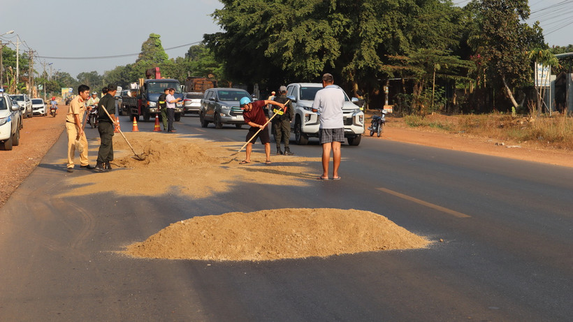 Trạm Cảnh sát Giao thông Đồng Phú và các lực lượng khắc phục sự cố trơn trượt trên Quốc lộ 14. (Ảnh: Đậu Tất Thành/TTXVN)