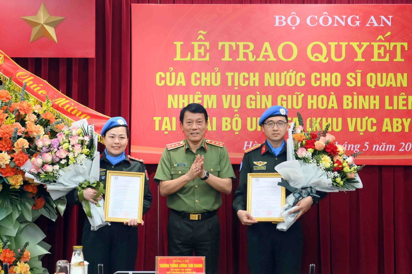 Thượng tướng Lương Tam Quang, Thứ trưởng Bộ Công an trao Quyết định của Chủ tịch nước cho 2 sỹ quan Công an Nhân dân đi thực hiện nhiệm vụ gìn giữ hòa bình Liên hợp quốc. (Ảnh: TTXVN phát)