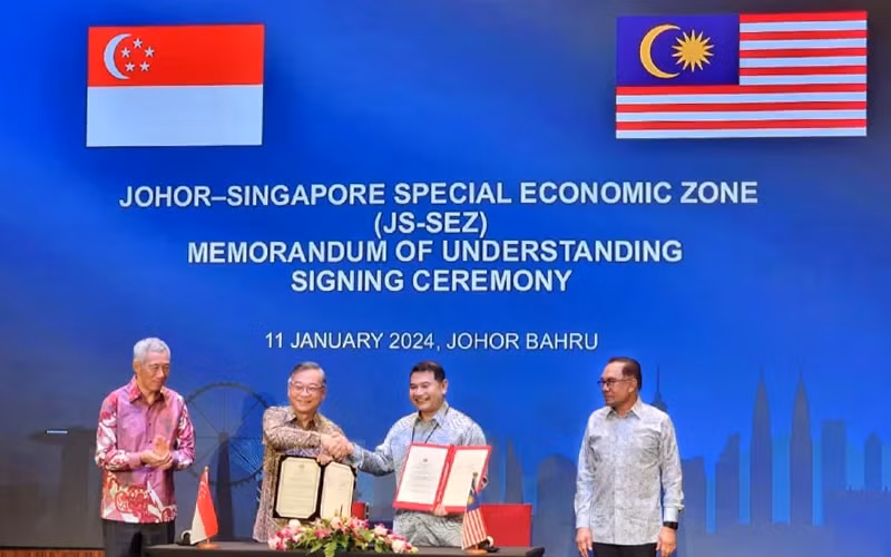 Bộ trưởng Kinh tế Malaysia Rafizi Ramli (thứ 2 từ phải sang) và Bộ trưởng Thương mại và Công nghiệp Singapore Gan Kim Yong ký biên bản ghi nhớ thành lập Đặc khu Kinh tế Johor-Singapore. (Nguồn: Bernama)
