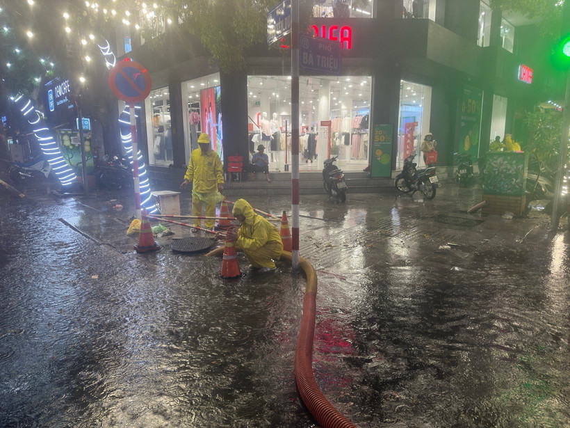 Lực lượng, phương tiện của Công ty TNHH Một thành viên Thoát nước Hà Nội ứng trực thoát nước trên phố Bà Triệu vào chiều tối 30/5 vừa qua. (Ảnh: TTXVN phát)