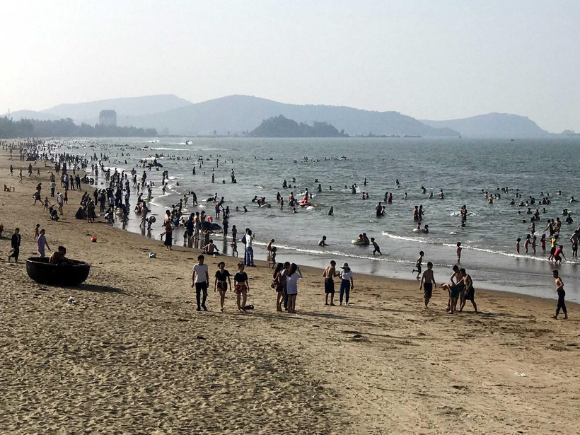 Du khách tắm mát và nghỉ dưỡng tại bãi biển Cửa Lò, tỉnh Nghệ An. (Ảnh: Tá Chuyên/TTXVN)