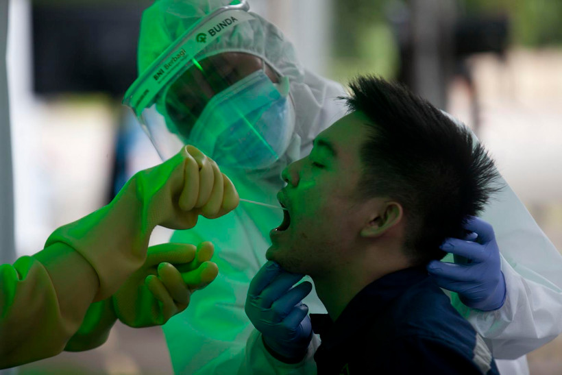 Nhân viên y tế lấy mẫu dịch xét nghiệm COVID-19 cho người dân tại Jakarta, Indonesia, ngày 20/5. (Ảnh: THX/TTXVN)