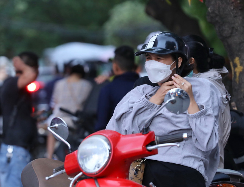 Gió lạnh, nhiệt độ giảm mạnh nhiều người phải mặc thêm áo. (Ảnh: Hoàng Hiếu/TTXVN)