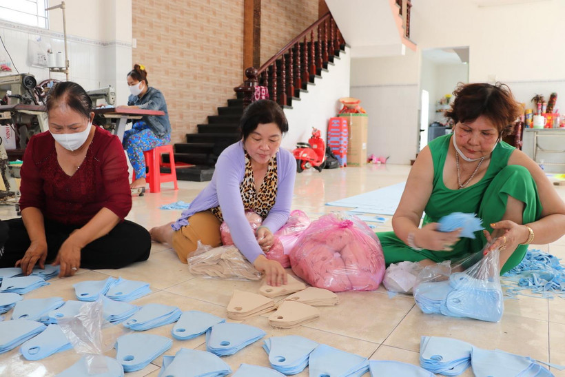 Các thành viên trong gia đình bà Nguyễn Thị Cội, ở thị trấn Tầm Vu, huyện Châu Thành cùng chị em phụ nữ chung sức cắt, may khẩu trang tặng người dân phòng dịch. (Ảnh: Đức Hạnh/TTXVN)
