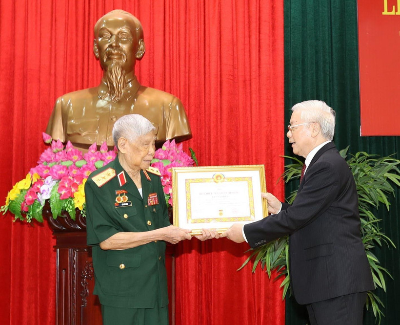 Tổng Bí thư, Chủ tịch nước Nguyễn Phú Trọng, Bí thư Quân ủy Trung ương trao Huy hiệu 70 năm tuổi Đảng tặng đồng chí Lê Khả Phiêu. (Ảnh: Trí Dũng/TTXVN)