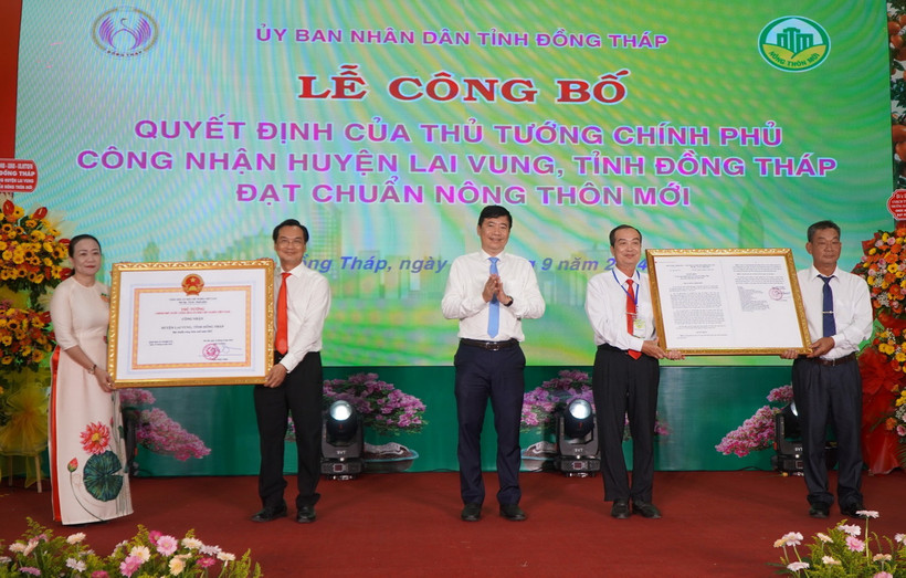 Chủ tịch UBND tỉnh Đồng Tháp Phạm Thiện Nghĩa trao Quyết định và Bằng công nhận huyện Lai Vung đạt chuẩn nông thôn mới. (Ảnh: Nhựt An/TTXVN)