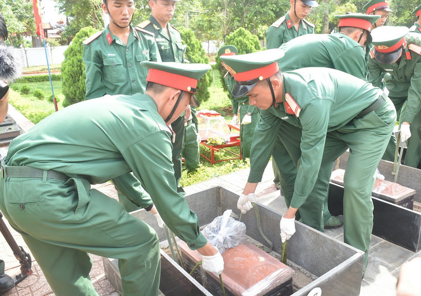 Nghi thức hạ quan hài cốt các liệt sỹ. (Ảnh: Nguyên Dung/TTXVN)