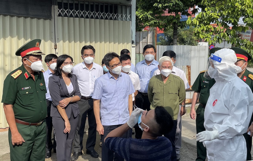 Phó Thủ tướng Vũ Đức Đam kiểm tra công tác test nhanh COVID-19 và khuyến khích người dân tự thử xét nghiệm. (Ảnh: Huyền Trang/TTXVN)