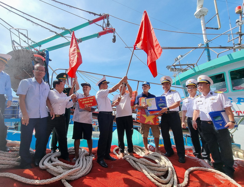 Bộ Tư lệnh Vùng 4 Hải quân tặng cờ Tổ quốc, áo phao và quà cho ngư dân tại cảng cá Mỹ Tân, xã Thanh Hải, huyện Ninh Hải, tỉnh Ninh Thuận. (Ảnh: Nguyễn Thành/TTXVN)