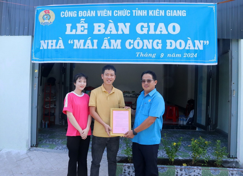 Ông Nguyễn Quốc Hùng, Chủ tịch Công đoàn Viên chức tỉnh Kiên Giang, trao quyết định bàn giao “Mái ấm Công đoàn” cho đoàn viên. (Ảnh: Lê Huy Hải/TTXVN)