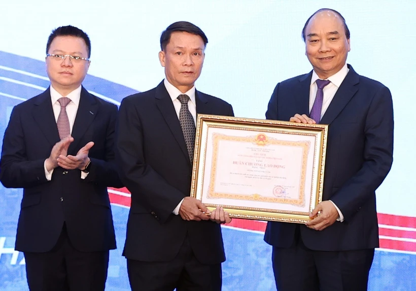 Thủ tướng Nguyễn Xuân Phúc, Chủ tịch Hội đồng Thi đua-Khen thưởng Trung ương, trao tặng Huân chương Lao động hạng Nhất cho Thông tấn xã Việt Nam. (Ảnh: Thống Nhất/TTXVN)