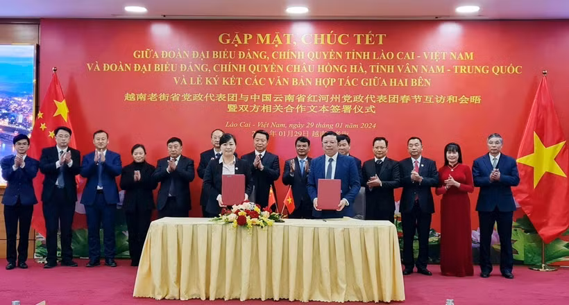 Lãnh đạo tỉnh Lào Cai và châu Hồng Hà chứng kiến các cơ quan chính quyền, đoàn thể, doanh nghiệp hai bên ký kết các biên bản thỏa thuận và ghi nhớ hợp tác. (Ảnh: Hương Thu/TTXVN)