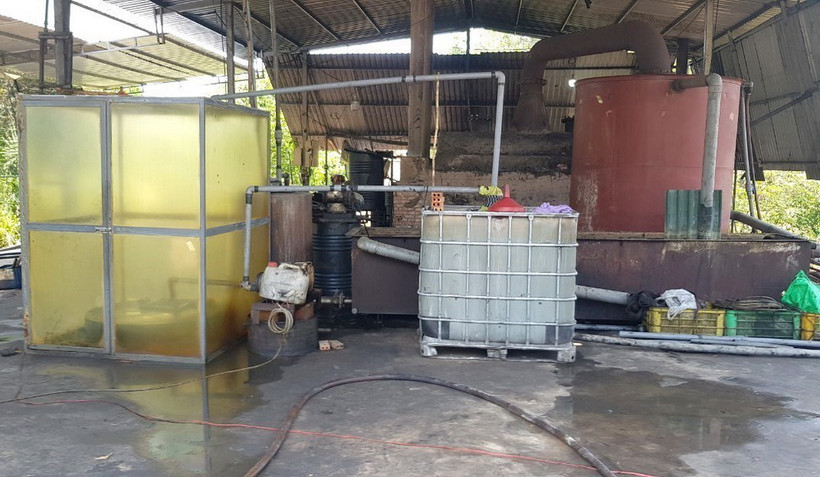 Toàn bộ quy trình tái chế nhớt thải trái phép thực hiện bằng phương pháp thủ công, lộ thiên qua đun nấu kết hợp với pha chế hóa chất độc hại. (Ảnh: TTXVN phát)
