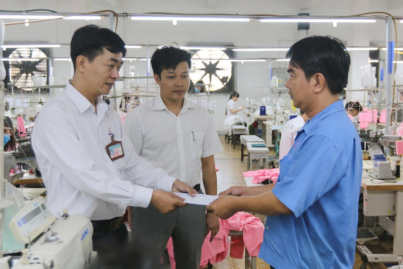 Ông Lê Văn Hải, Phó Tổng Giám đốc Công ty Cổ phần Thương mại xuất nhập khẩu May Phương Nam, quận Gò Vấp (giữa) cùng Chủ tịch Công đoàn Công ty Trần Phú Vinh (trái) tặng quà Tết Dương lịch 2020 cho công nhân lao động có hoàn cảnh khó khăn. (Ảnh: Thanh Vũ/T