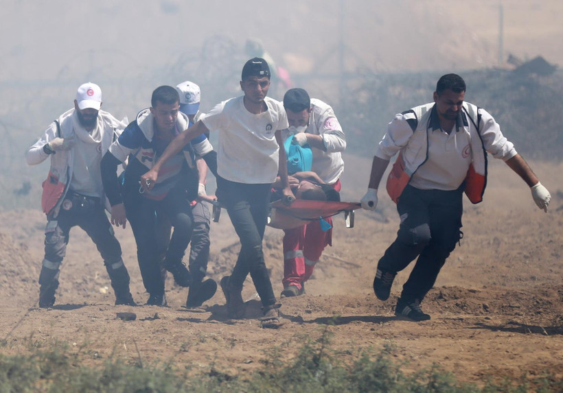 Nhân viên y tế chuyển người biểu tình Palestine bị thương trong cuộc đụng độ với binh sỹ Israel tại biên giới Dải Gaza - Israel ngày 15/5 vừa qua. (Ảnh: THX/TTXVN)