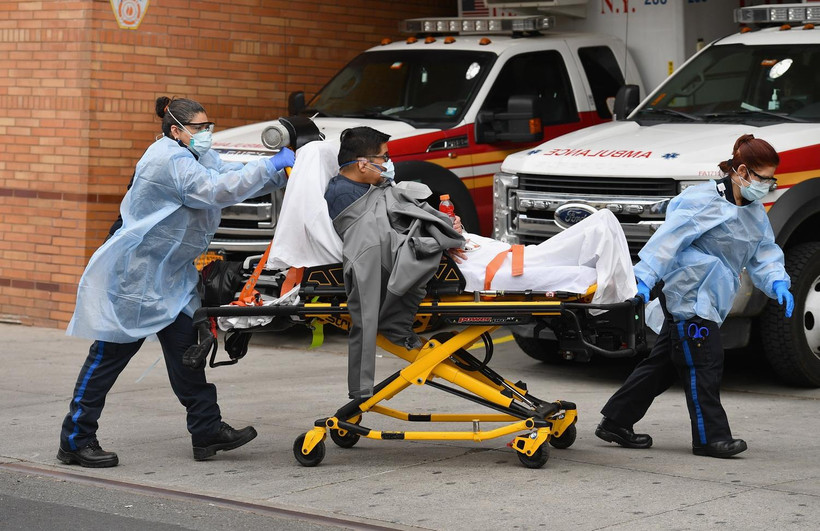 Nhân viên y tế chuyển bệnh nhân mắc COVID-19 vào một bệnh viện ở New York, Mỹ. (Ảnh: AFP/TTXVN)
