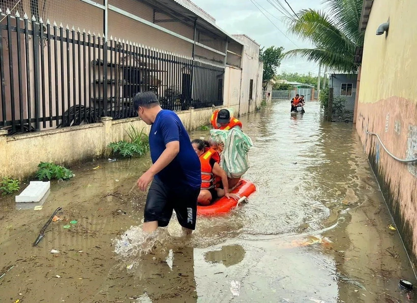 Cán bộ, chiến sỹ Ban Chỉ huy Quân sự thành phố Phú Quốc, tỉnh Kiên Giang, cùng với lực lượng địa phương ứng cứu, sơ tán người dân đến nơi an toàn do mưa lớn gây ngập cục bộ trên đảo. (Ảnh: TTXVN phát)