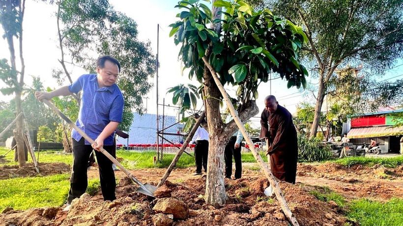 Lãnh đạo Thành ủy, UBND thành phố Thủ Dầu Một, tỉnh Bình Dương tham gia trồng cây ăn quả phủ xanh đất công để tạo công viên. (Ảnh: TTXVN phát)