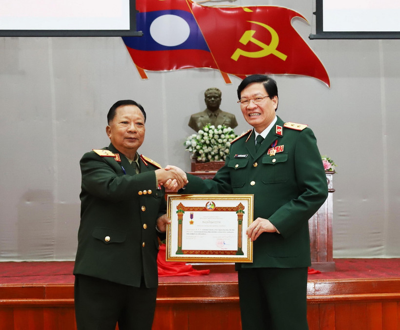 Phó Thủ tướng, Bộ trưởng Bộ Quốc phòng Lào, Đại tướng Chansamone Chanyalath trao Huân chương Lao động hạng Nhất cho Trung tướng, Phó Giáo sư-Tiến sỹ Nguyễn Xuân Kiên, Giám đốc Học viện Quân y Việt Nam. (Ảnh: Xuân Tú/TTXVN)