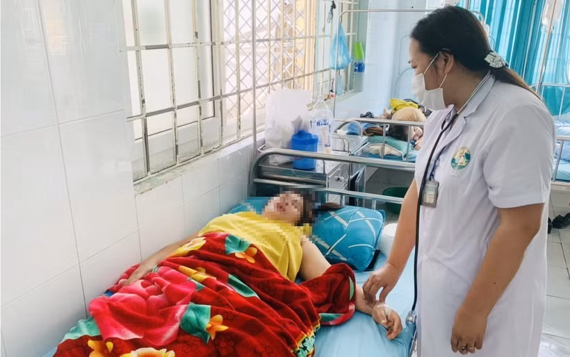 Bác sỹ của một trung tâm Y tế huyện thăm khám cho các bệnh nhân bị ngộ độc sau khi đi ăn đám cưới. (Ảnh: TTXVN phát)