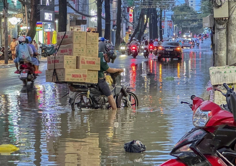 Người dân gặp khó khăn khi di chuyển do nước ngập trên đường Nguyễn Trãi, quận Ninh Kiều, thành phố Cần Thơ. (Ảnh: Thanh Liêm/TTXVN)