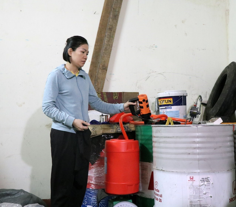 Đối tượng Quách Thị Thu Hồng thực hiện lại hành vi san chiết nhớt giả. (Ảnh: Xuân Triệu/TTXVN)