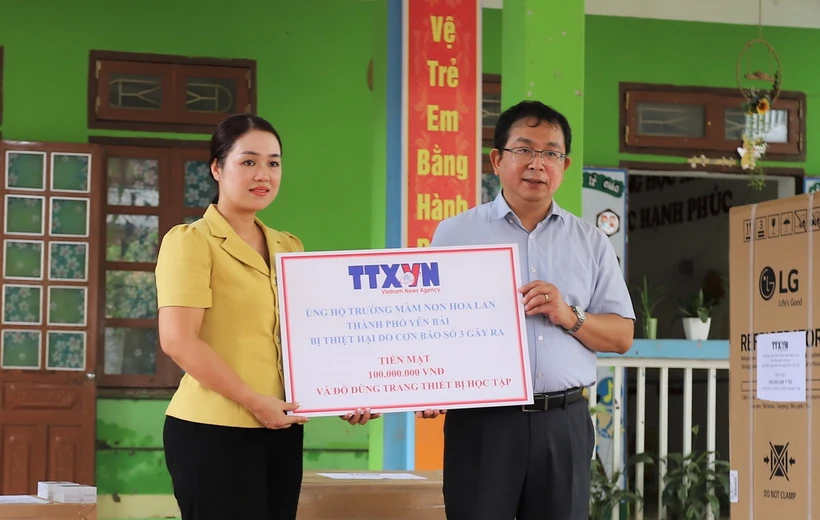 Phó Tổng giám đốc TTXVN Nguyễn Tuấn Hùng trao tặng số tiền 100 triệu đồng của TTXVN hỗ trợ Trường Mầm non Hoa Lan, phường Hồng Hà, thành phố Yên Bái khắc phục thiệt hại của bão số 3. (Ảnh: Tiến Khánh/TTXVN)