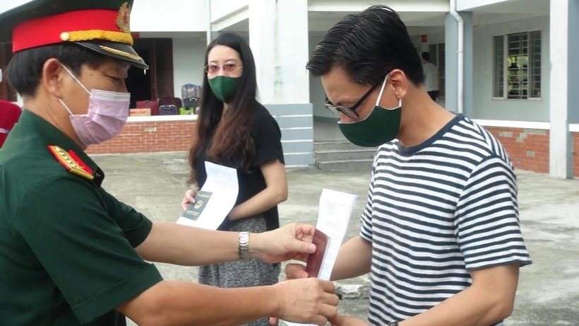 Đại tá Nguyễn Hữu Nghĩa, Phó Chỉ huy trưởng Bộ Chỉ huy Quân sự tỉnh Quảng Nam trao quyết định hoàn thành nhiệm vụ cách ly y tế tập trung cho công dân. (Ảnh: Hữu Trung/TTXVN)