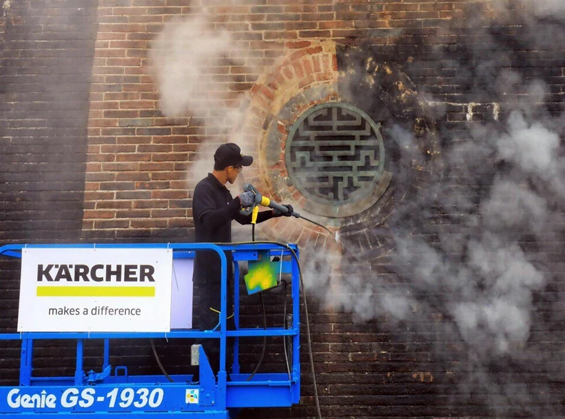 Các chuyên gia Karcher làm sạch di tích cổng Ngọ Môn, Đại nội Huế bằng công nghệ hơi nước nóng. (Ảnh: Quốc Việt/TTXVN)