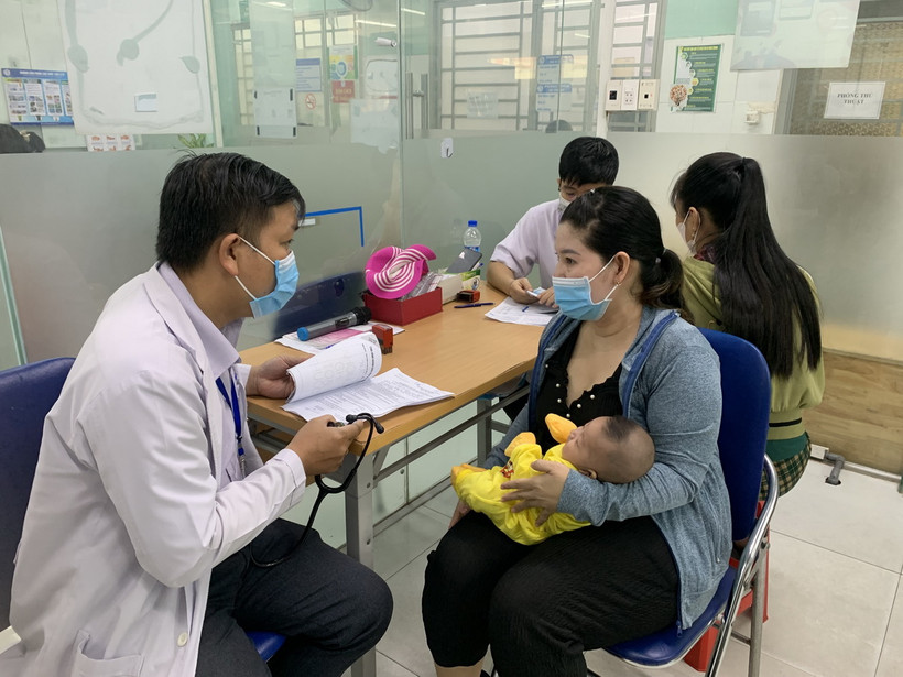 Phụ huynh đưa trẻ đi tiêm vaccine phòng bệnh sởi. (Ảnh: Đinh Hằng/TTXVN)