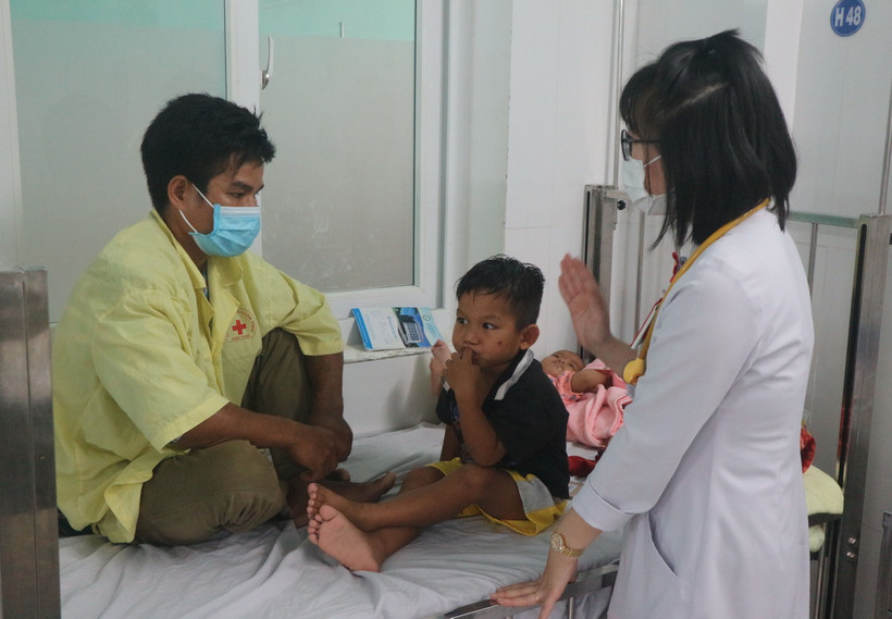 Bác sỹ kết hợp thăm, khám với tuyên truyền cho phụ huynh về cách phòng, chống bệnh trên trẻ em. (Ảnh: Dư Toán/TTXVN)