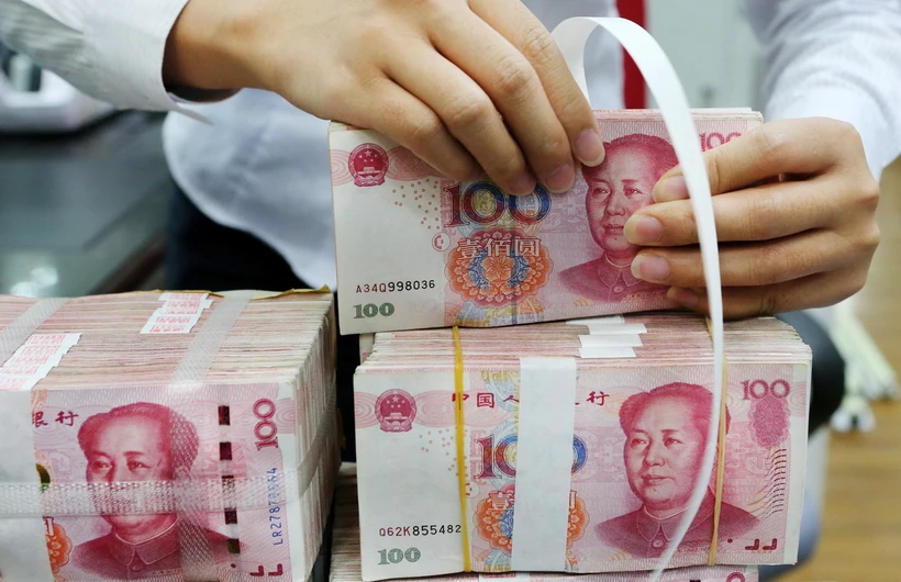 Kiểm tiền mệnh giá 100 nhân dân tệ tại ngân hàng ở tỉnh Giang Tô, Trung Quốc. (Ảnh: AFP/TTXVN)