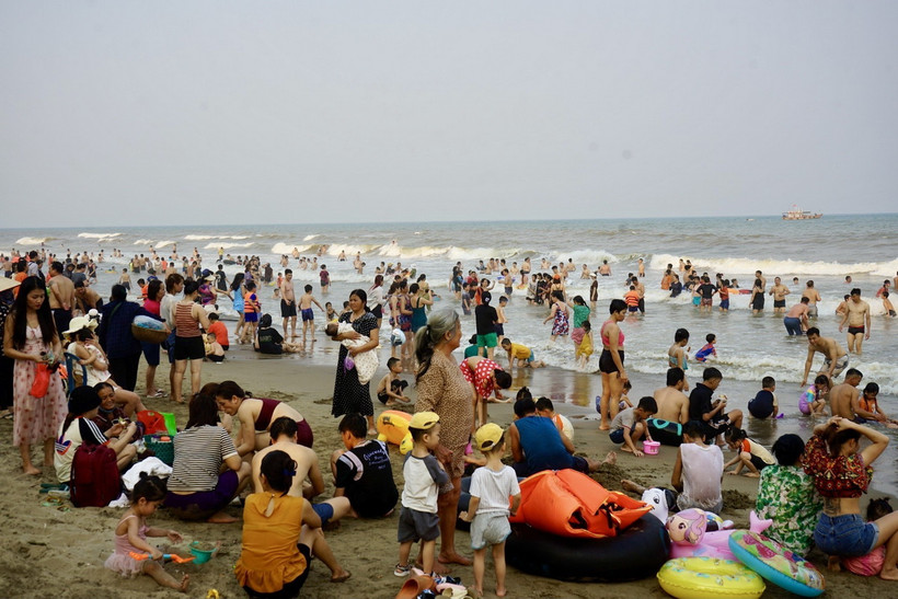 Du khách và người dân địa phương dồn về Bãi biển Sầm Sơn tránh nóng. (Ảnh: Hoa Mai/TTXVN)