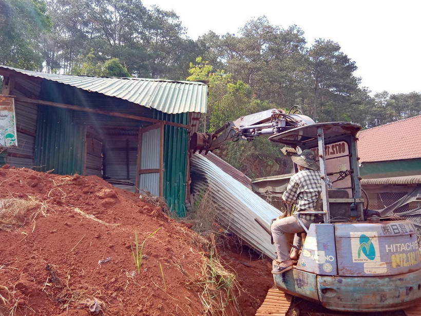 Lực lượng chức năng cưỡng chế, tháo dỡ các trường hợp xây dựng nhà, lều tạm trên đất rừng ven đường Hồ Chí Minh, đoạn qua xã Nâm N’jang, huyện Đắk Song, tỉnh Đắk Nông. (Ảnh: TTXVN phát)