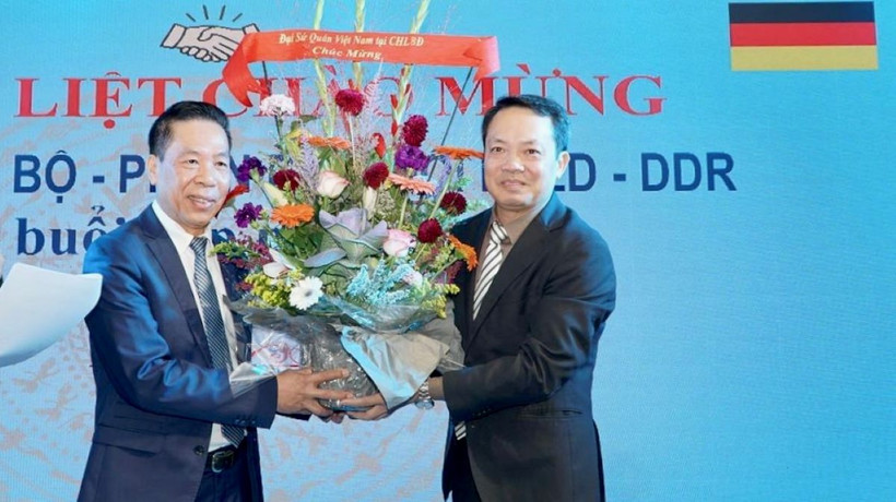 Ông Phạm Huy Phương, Bí thư thứ nhất, Thường trực ban Công tác Cộng đồng Đại sứ quán Việt Nam tặng hoa cựu cán bộ, phiên dịch và đội trưởng hợp tác lao động Việt Nam và CHDC Đức. (Ảnh: Phương Hoa/Vietnam)